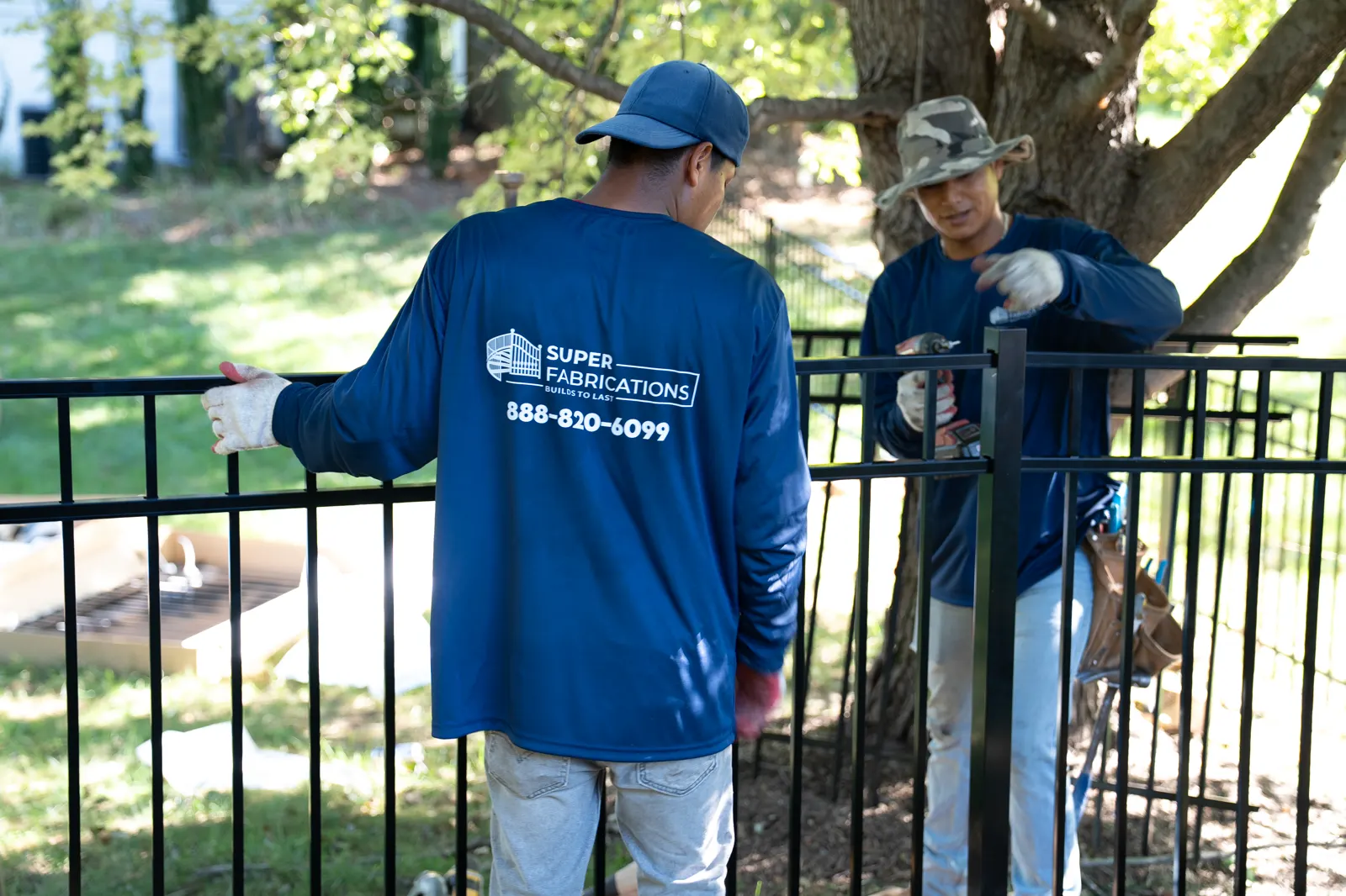 Crew installing a black aluminum fence, under Our Fencing Projects