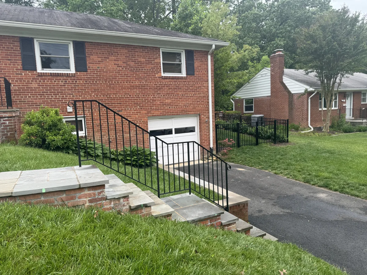 Black aluminum fence wrapping a corner lot, under Our Fencing Projects