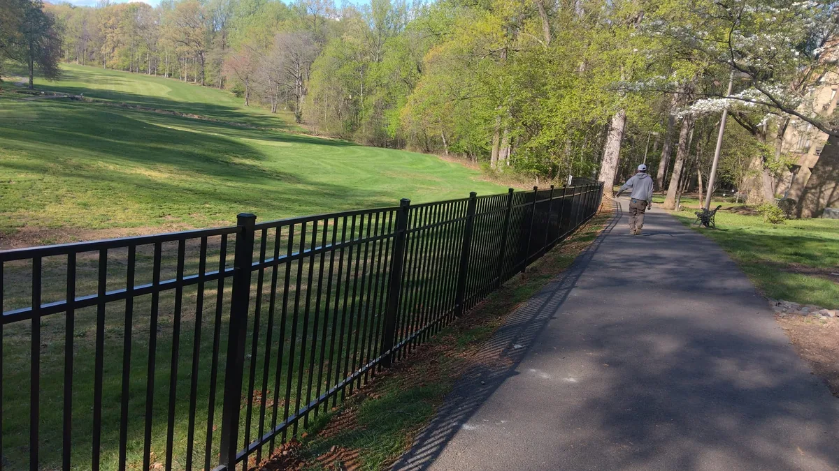 Black aluminum fence across an open lawn, under Our Fencing Projects