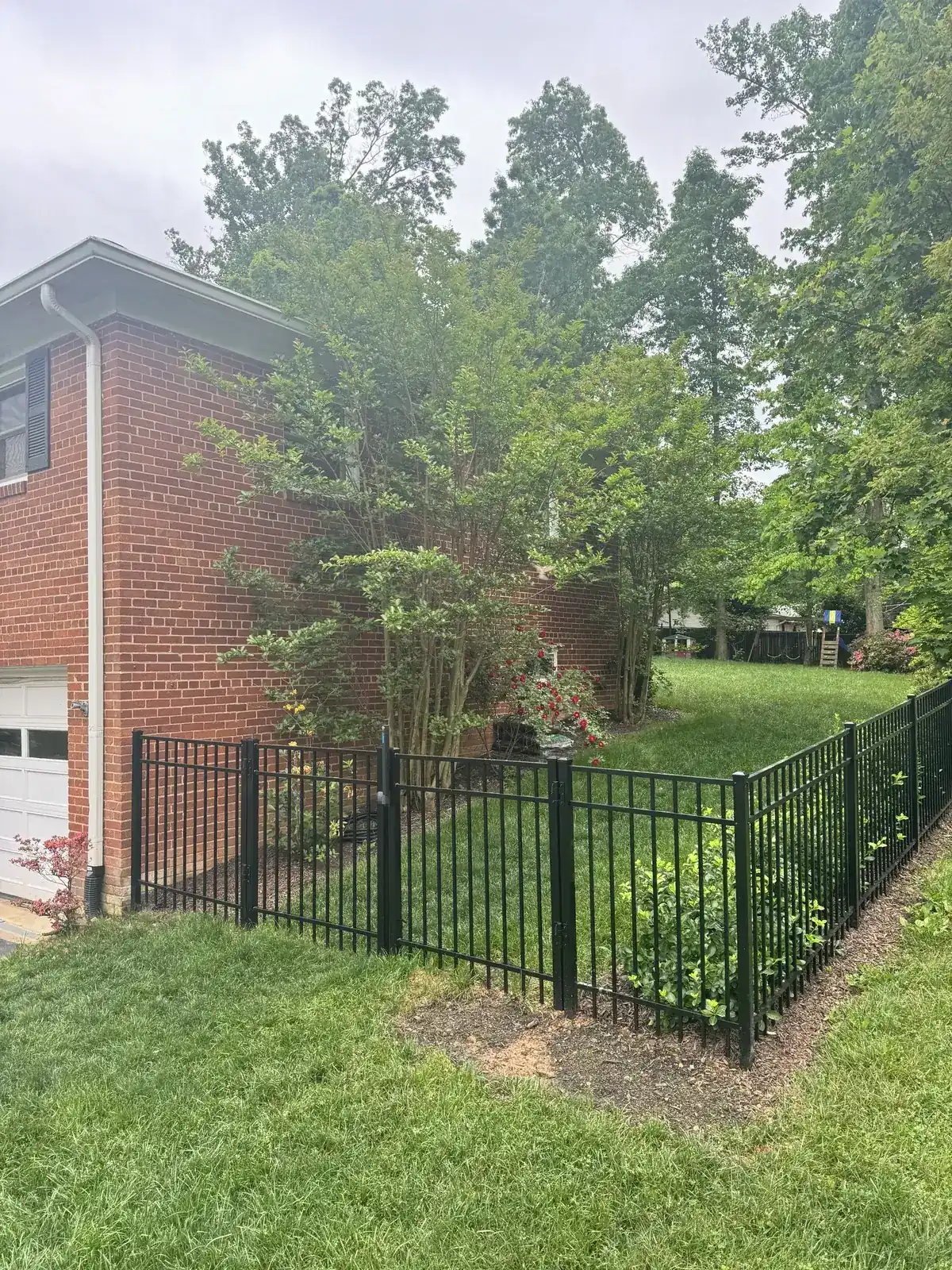 Black aluminum fence beside a pool area, under Our Fencing Projects