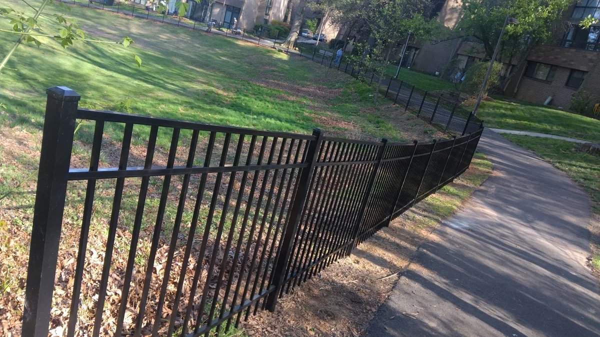 Black aluminum fence along a walking trail, under Our Fencing Projects