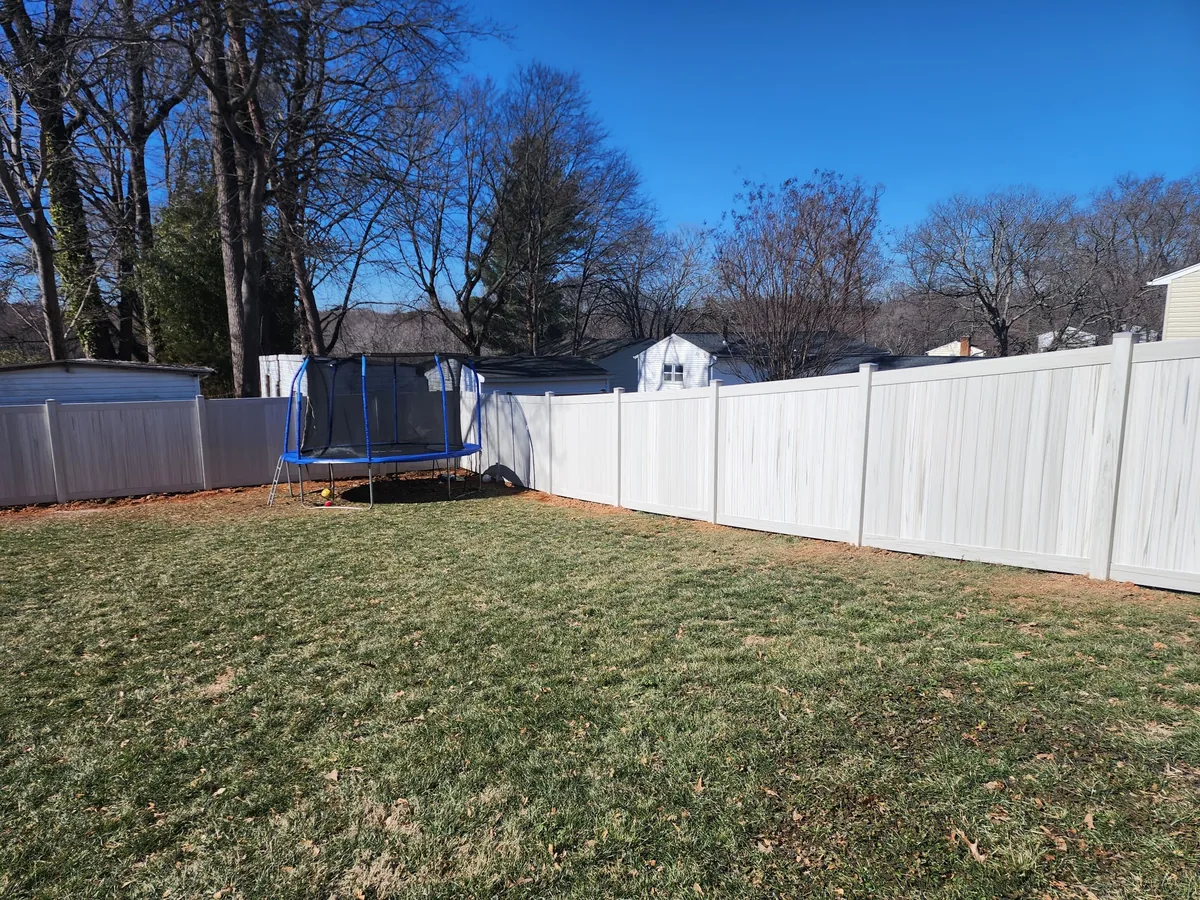 Aspen-style vinyl privacy fence in tree shade, under Our Fencing Projects