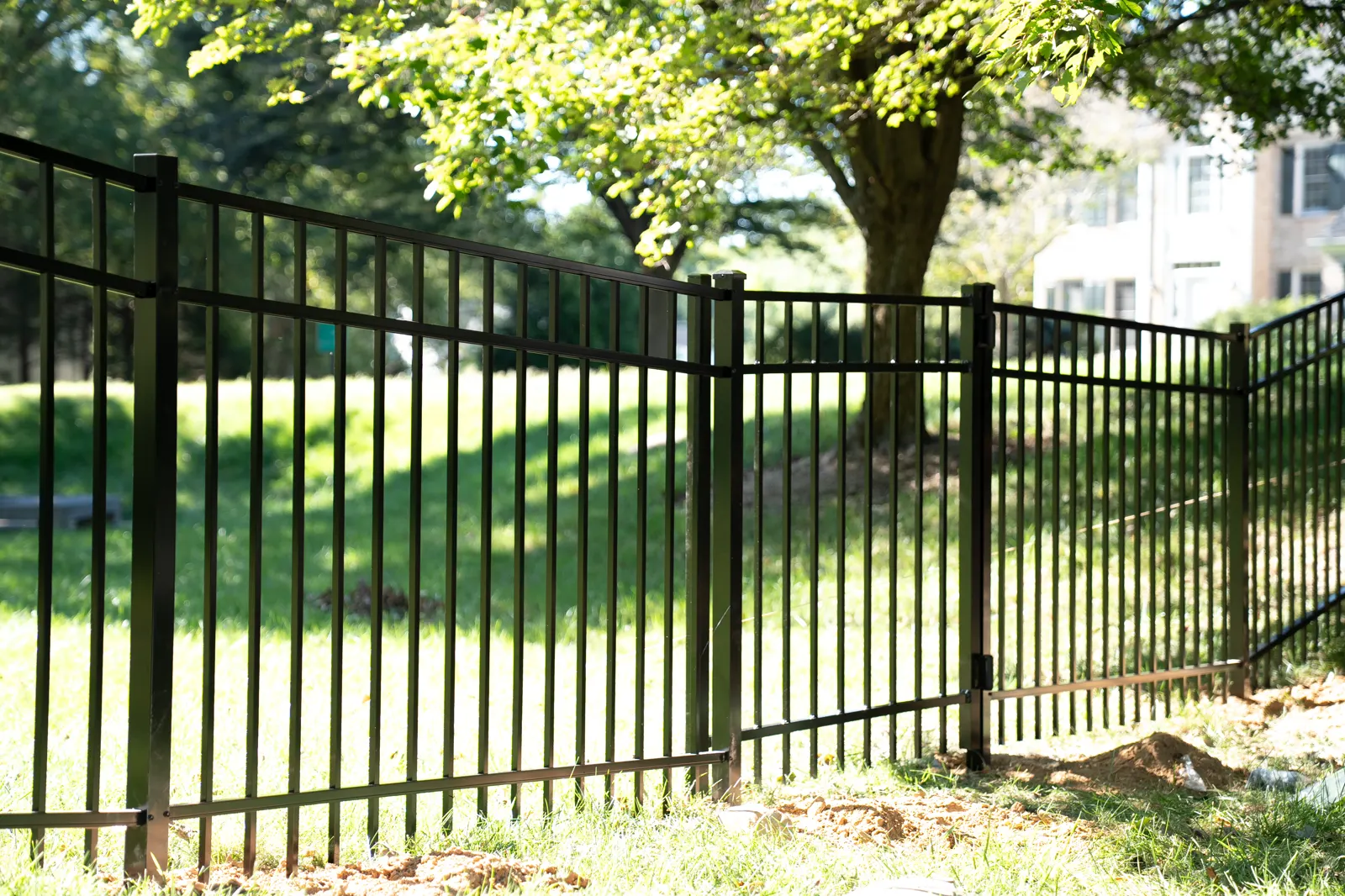 Black aluminum fence and gate on a lawn, under Our Fencing Projects
