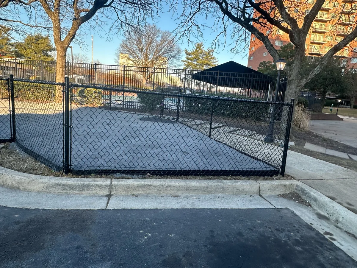 Black vinyl-coated chain link fence line, under Our Fencing Projects