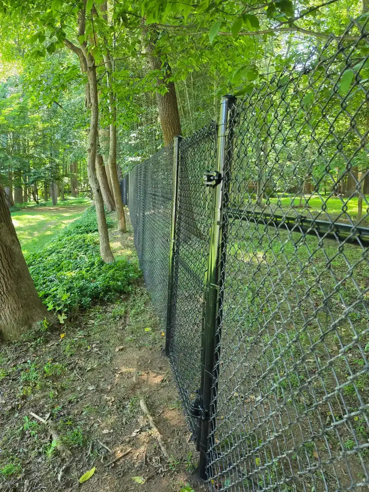 Black vinyl-coated chain link fence without top rail, under Our Fencing Projects