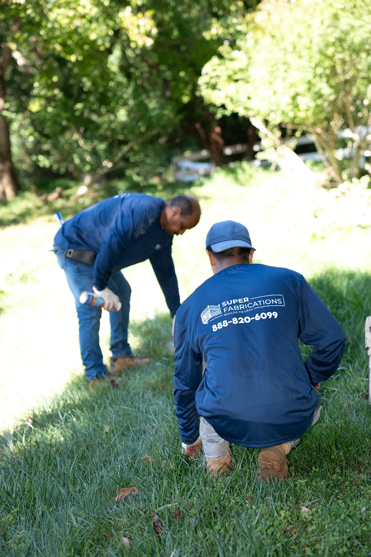 Crew member setting a post for a black aluminum fence, under Our Fencing Projects