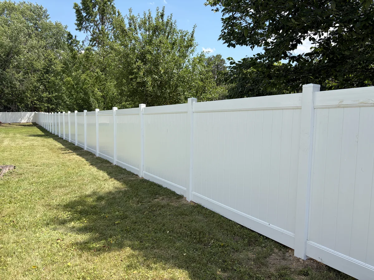 White Nexus-style vinyl privacy fence along a lawn, under Our Fencing Projects