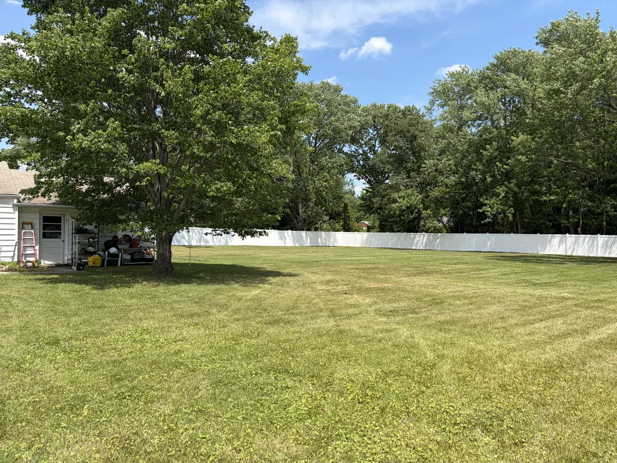 Wide-panel white vinyl privacy fence, under Our Fencing Projects