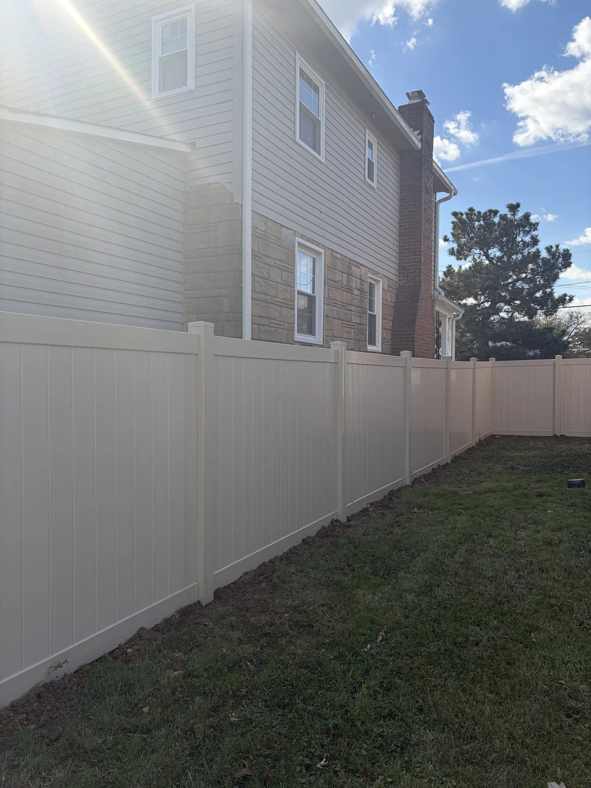 Tan vinyl privacy fence around a backyard, under Our Fencing Projects