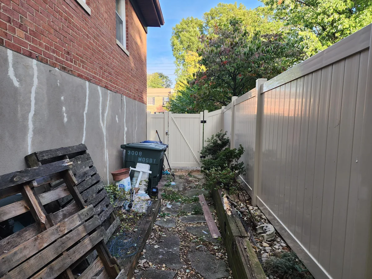 Tan vinyl privacy fence with a side gate, under Our Fencing Projects