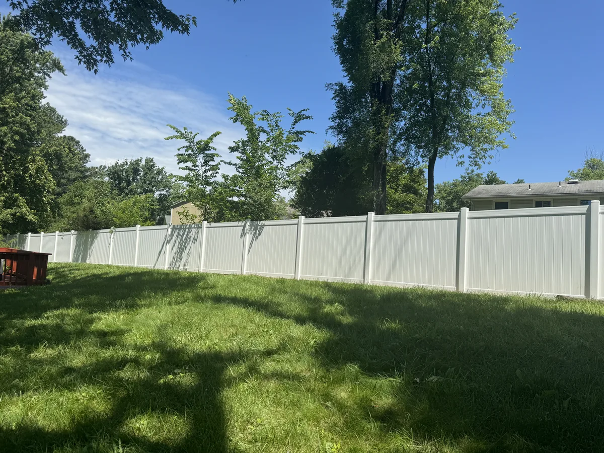 White vinyl privacy fence along a property line, under Our Fencing Projects