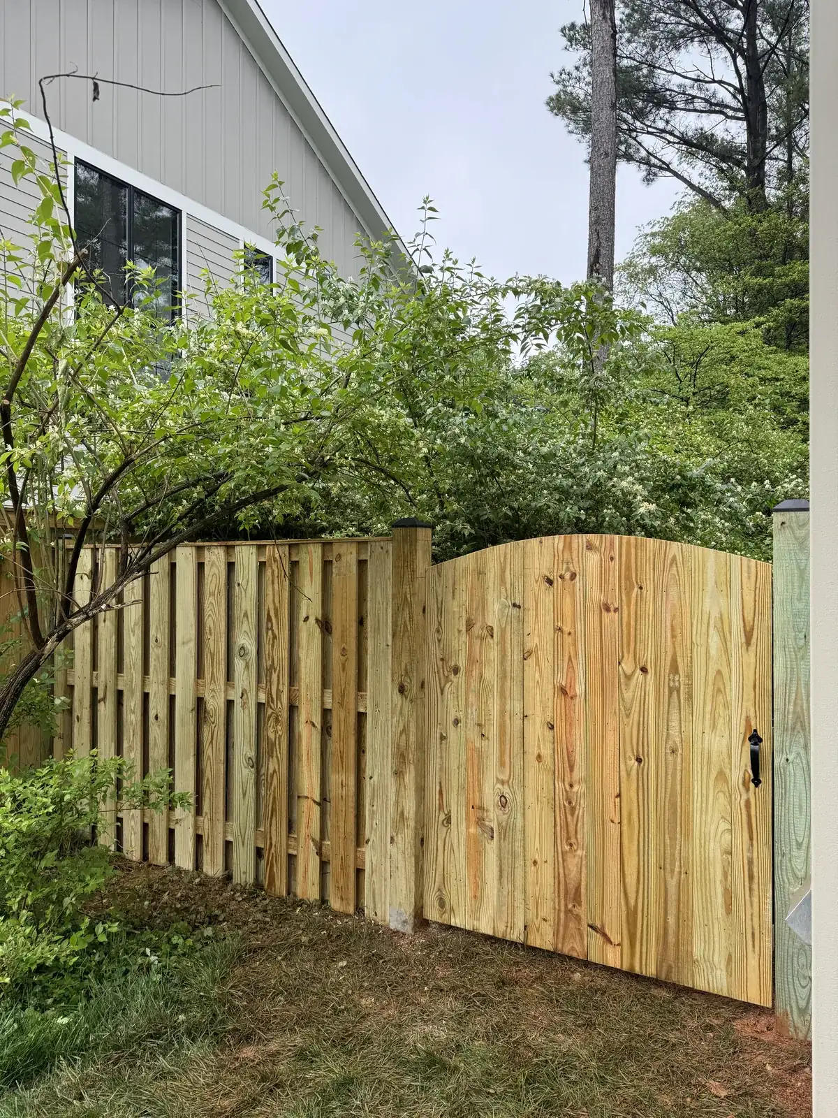 Wood shadowbox fence turning a backyard corner, under Our Fencing Projects