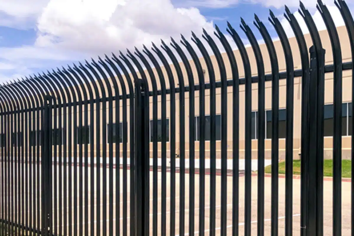 Black metal security fence with spear-top design in front of a commercial building on a sunny day in Northern Virginia