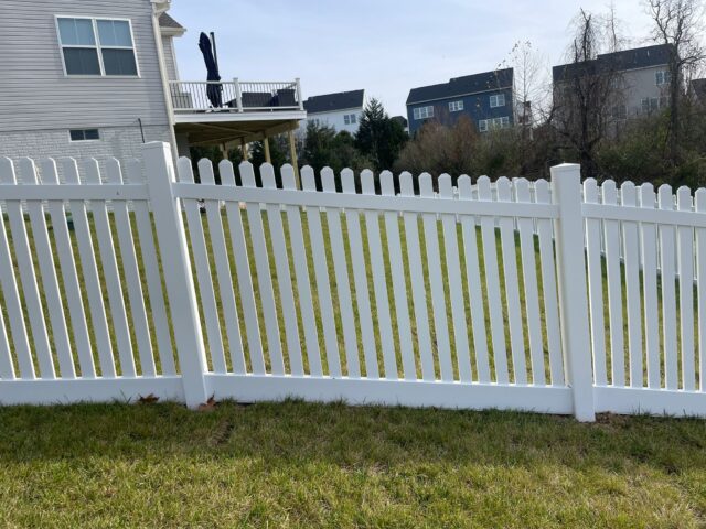 a white vinyl fence in front of a house