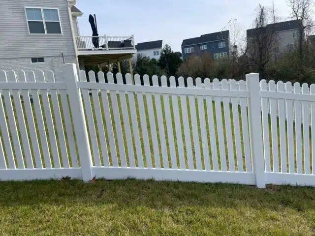 a white vinyl fence in front of a house